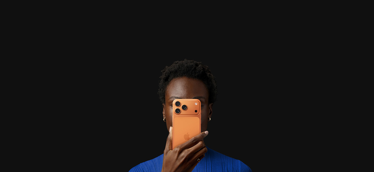 En person holder en iPhone 17 Pro i farven kosmisk orange foran sit ansigt med bagsiden vendt udad.