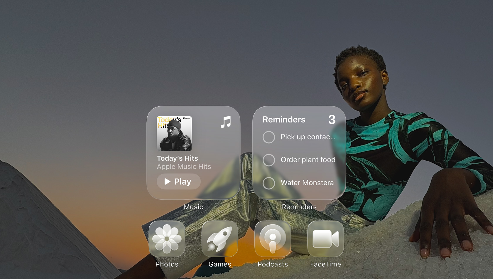 Layar Liquid Glass dengan ikon aplikasi yang jernih, seperti Apple Music, Pengingat, Foto, Game, Podcast, dan FaceTime yang membias di depan wallpaper