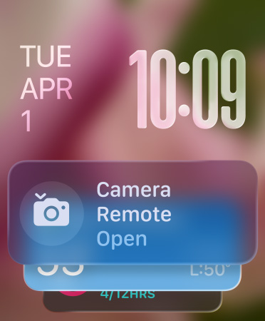 Widget Remote Kamera muncul di bagian bawah layar, angka jam tembus pandang di kanan atas, tanggal di kiri atas